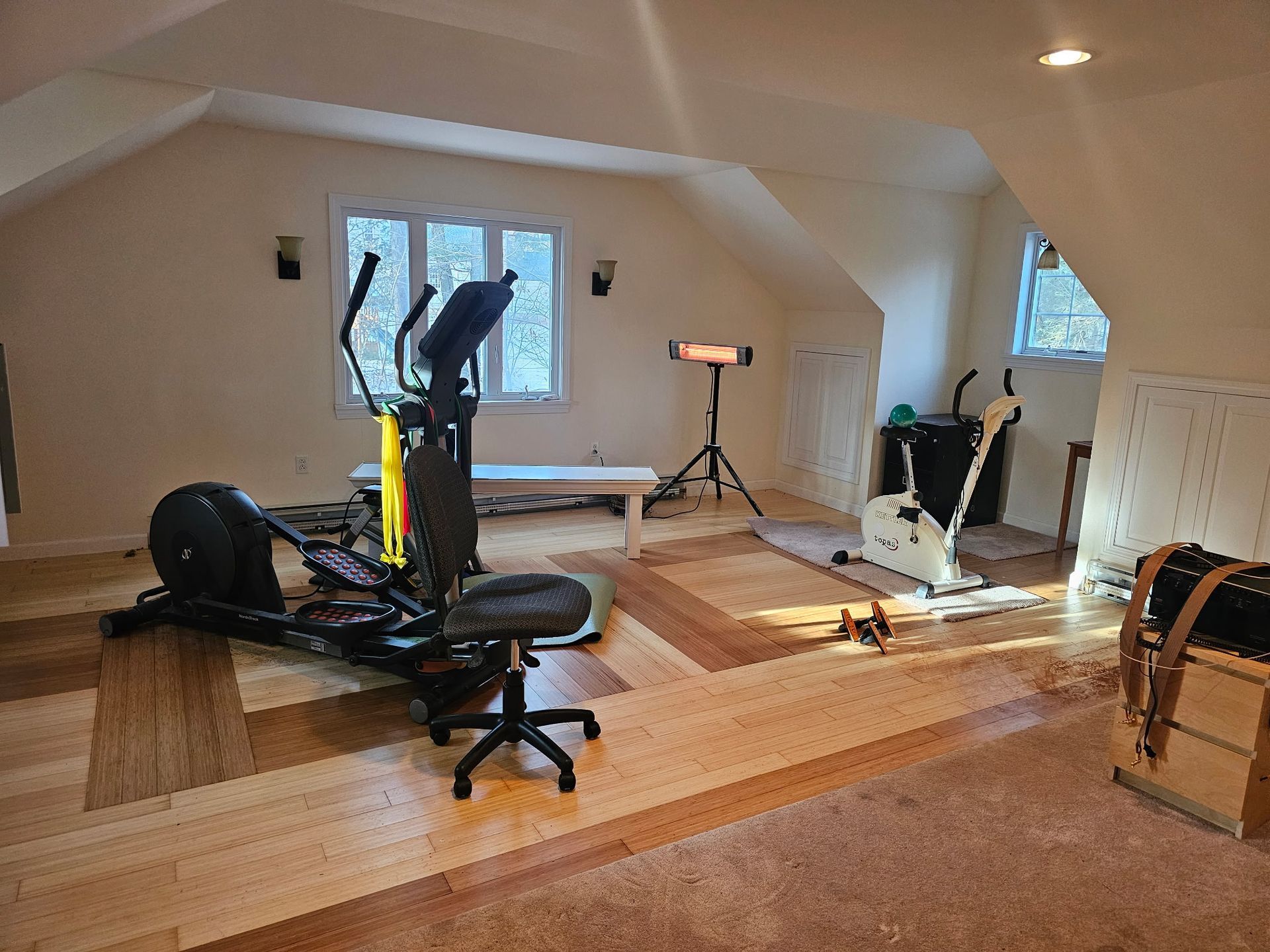 A room with a lot of exercise equipment in it.