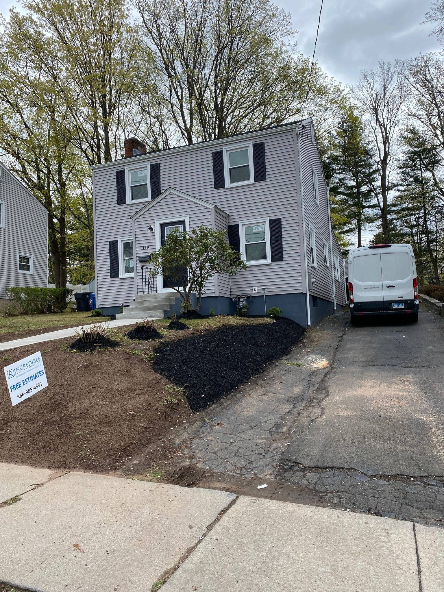 A white van is parked in front of a house.