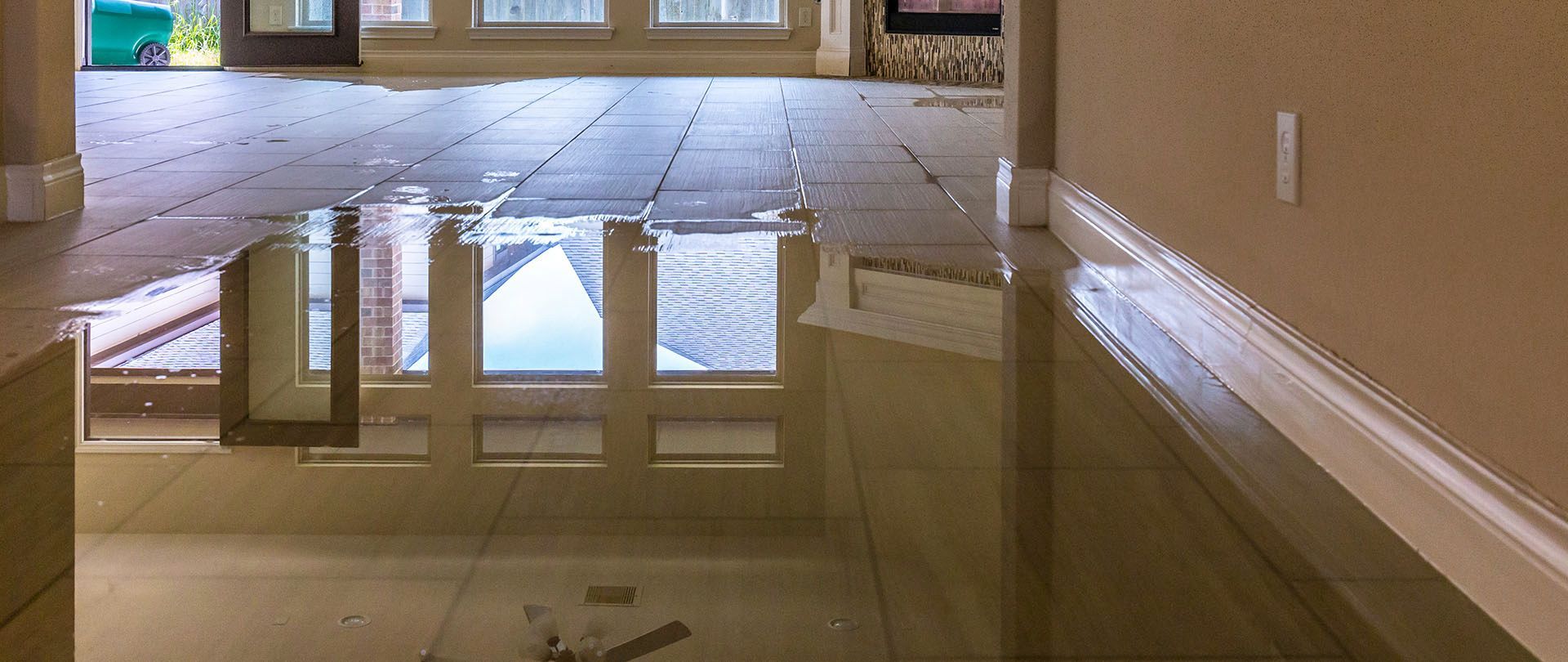 Flooded interior of a home reflecting the windows.