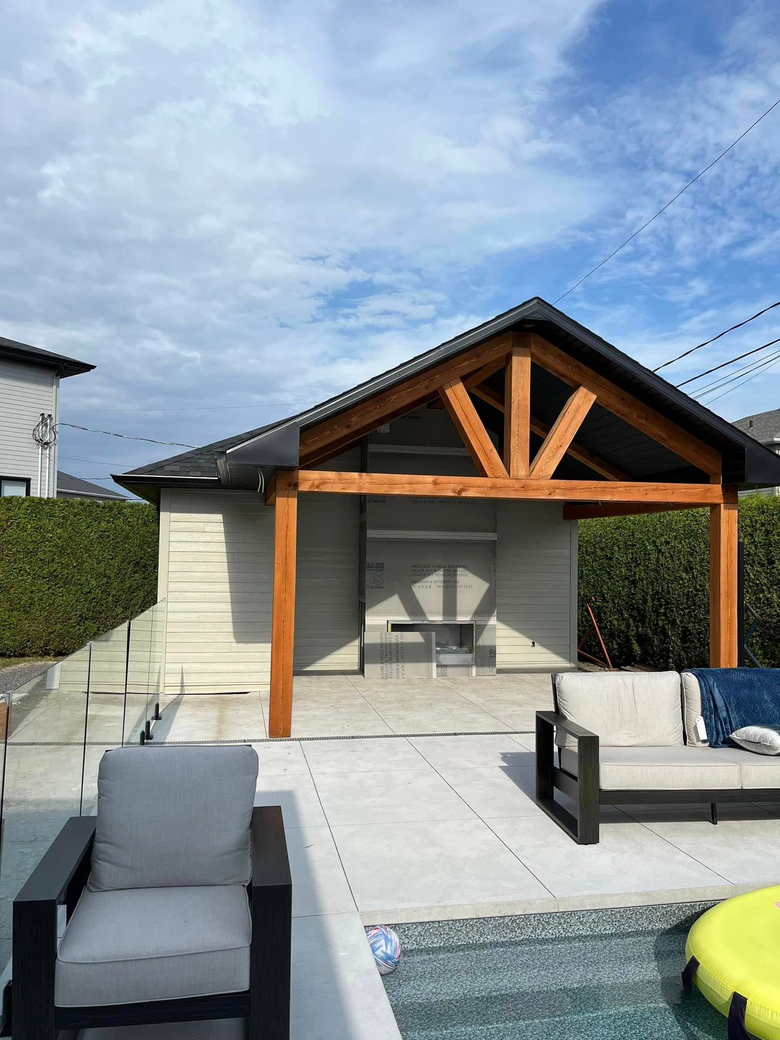 Cabane au bord de la piscine avec toit à poutres apparentes, sièges et vue sur la piscine.