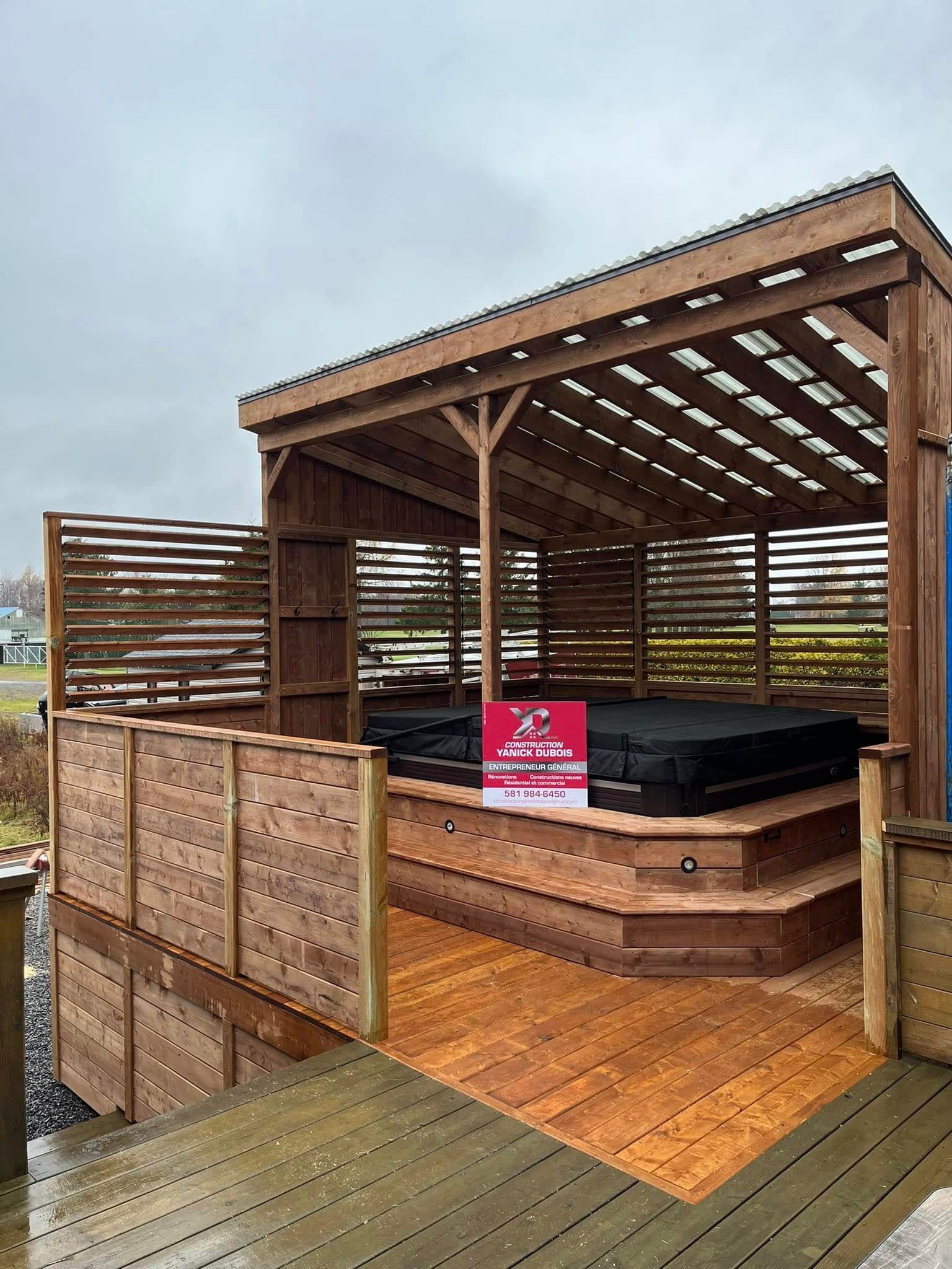 Abri pour jacuzzi en bois avec marches, toit en pergola et parois Ă claire-voie.