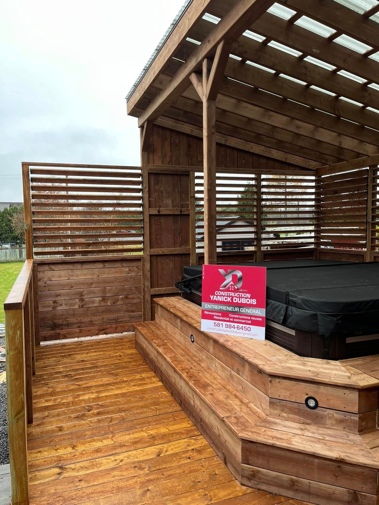 Terrasse en bois avec jacuzzi, panneaux d'intimité à lattes et toit partiellement couvert.