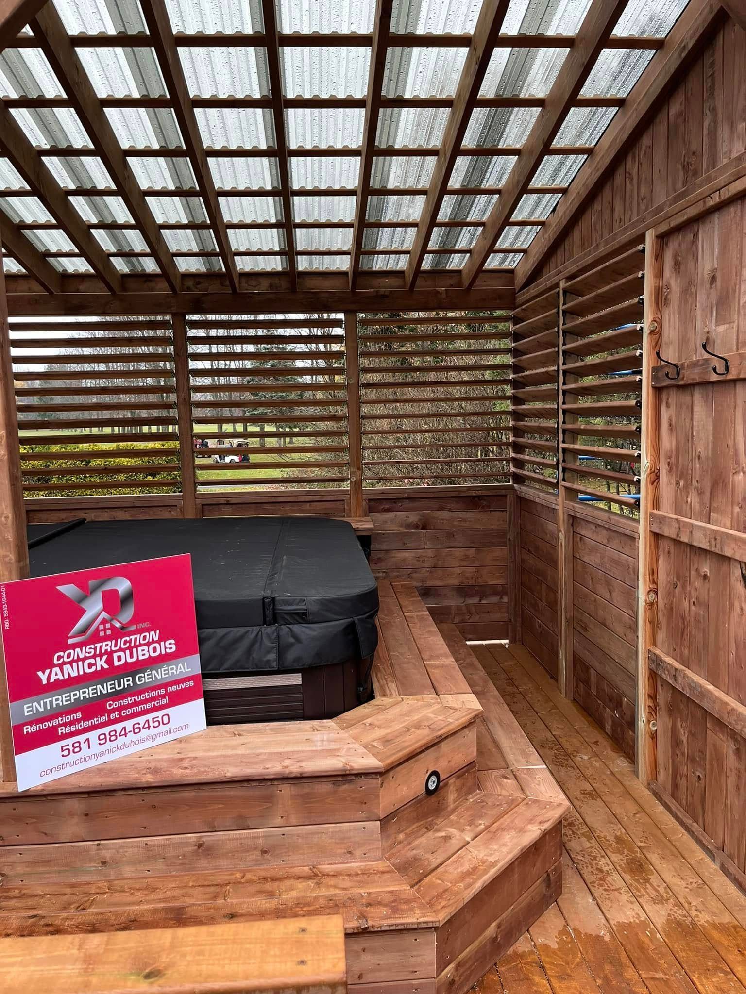 Abri pour spa en bois avec marches, parois à persiennes et couvercle sur la baignoire.