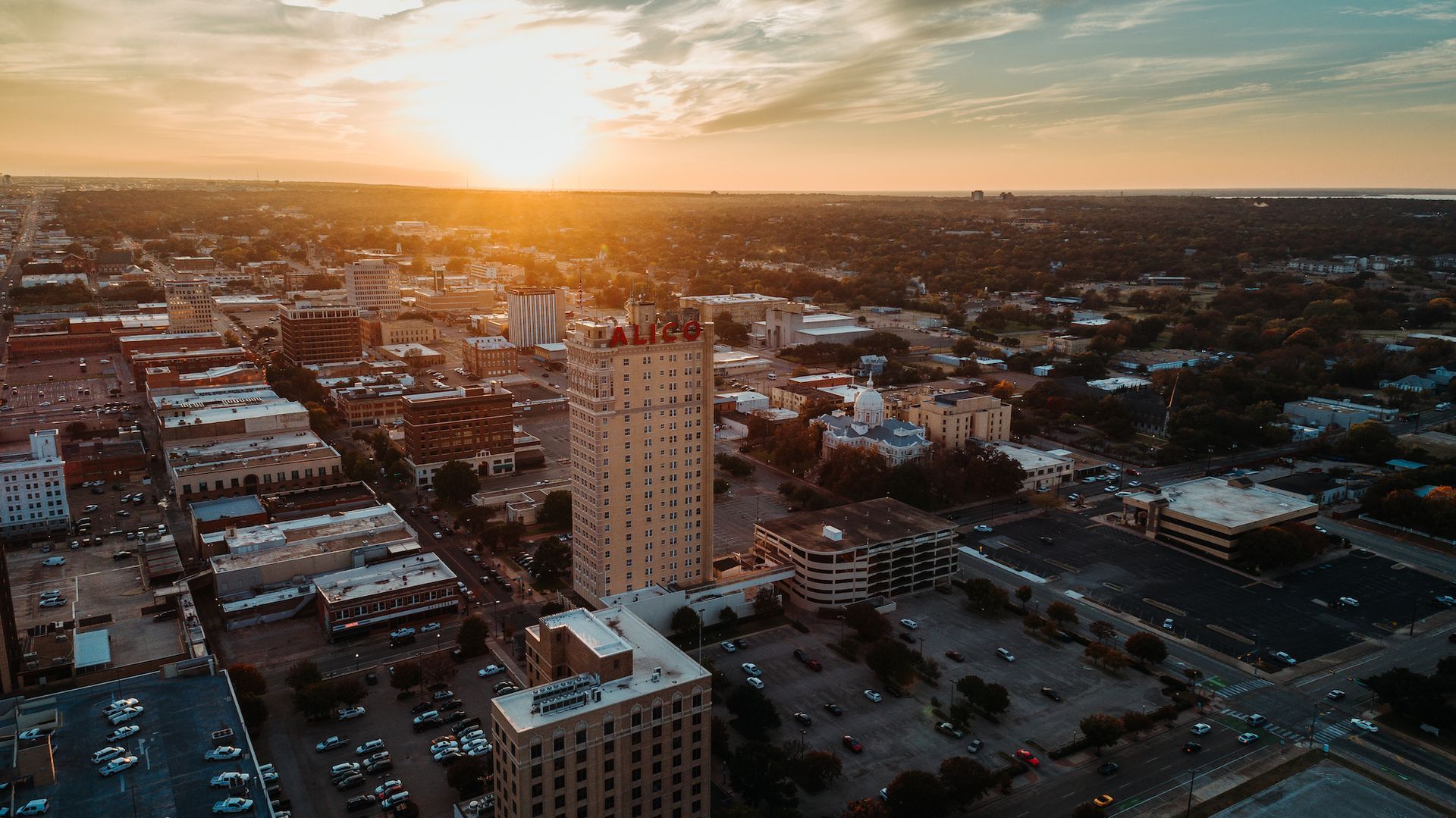 Aerial view of downtown Waco, TX at sunset featuring the ALICO building, and city streets
