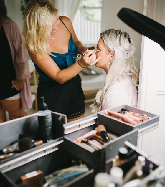 A woman is applying makeup to another woman 's face