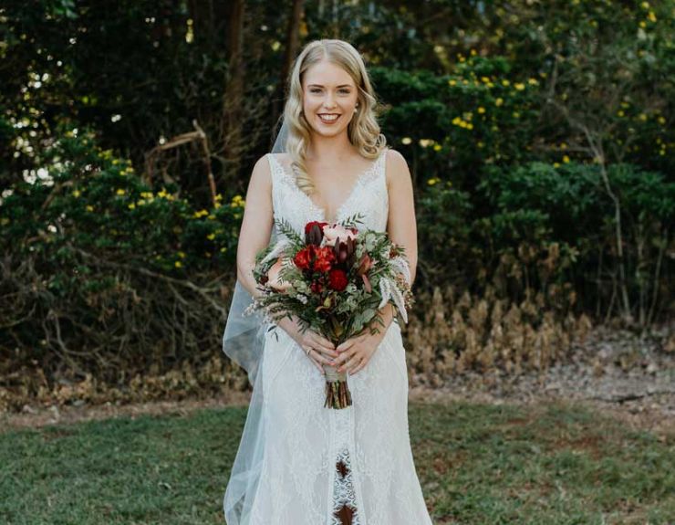 The bride is wearing a white dress and holding a bouquet of flowers.