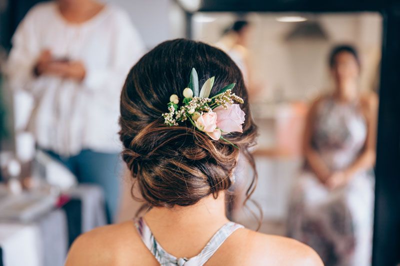 A woman is getting her hair done in front of a mirror.