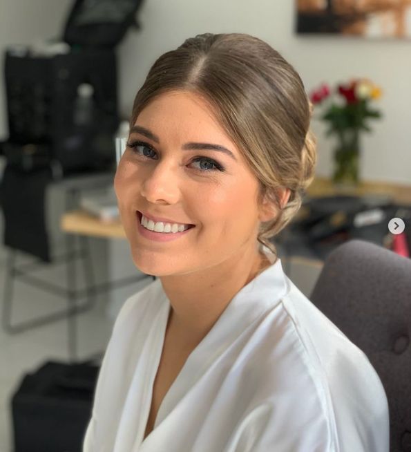 A woman in a white robe is smiling for the camera