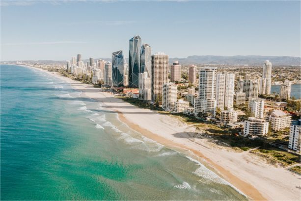 A blurred image of a beach with a city in the background.