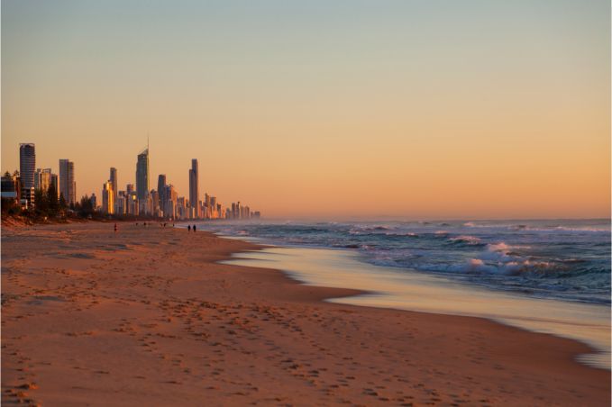 A blurred image of a beach with a city in the background.