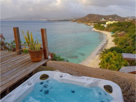 A hot tub with a view of a beach and ocean