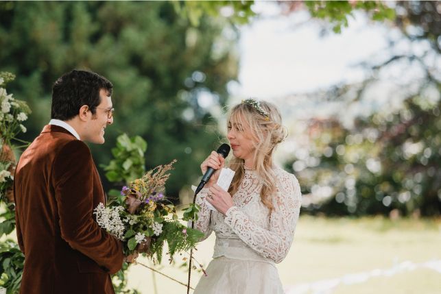 A bride and groom are posing for a picture on the beach.