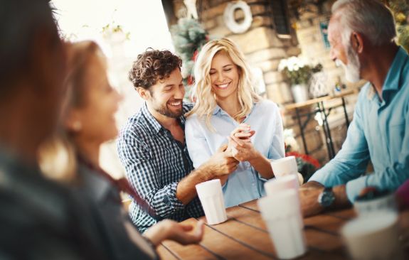 A group of people are sitting around a table eating ice cream.