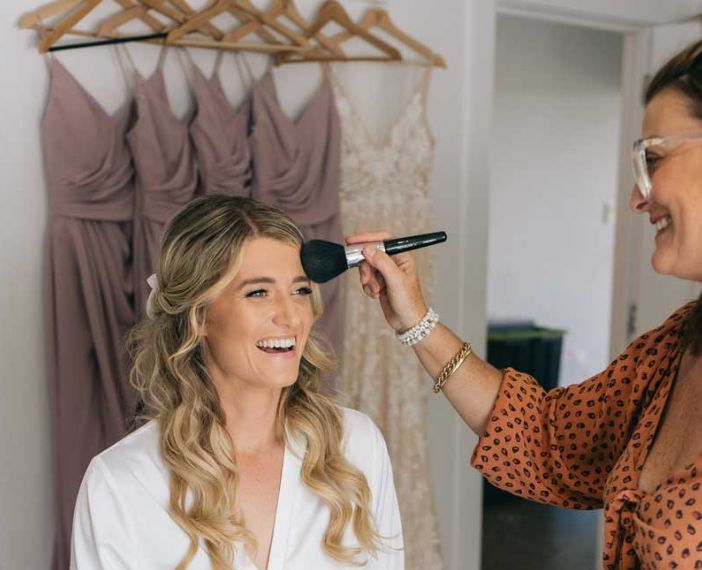 A woman is applying makeup to another woman 's face.