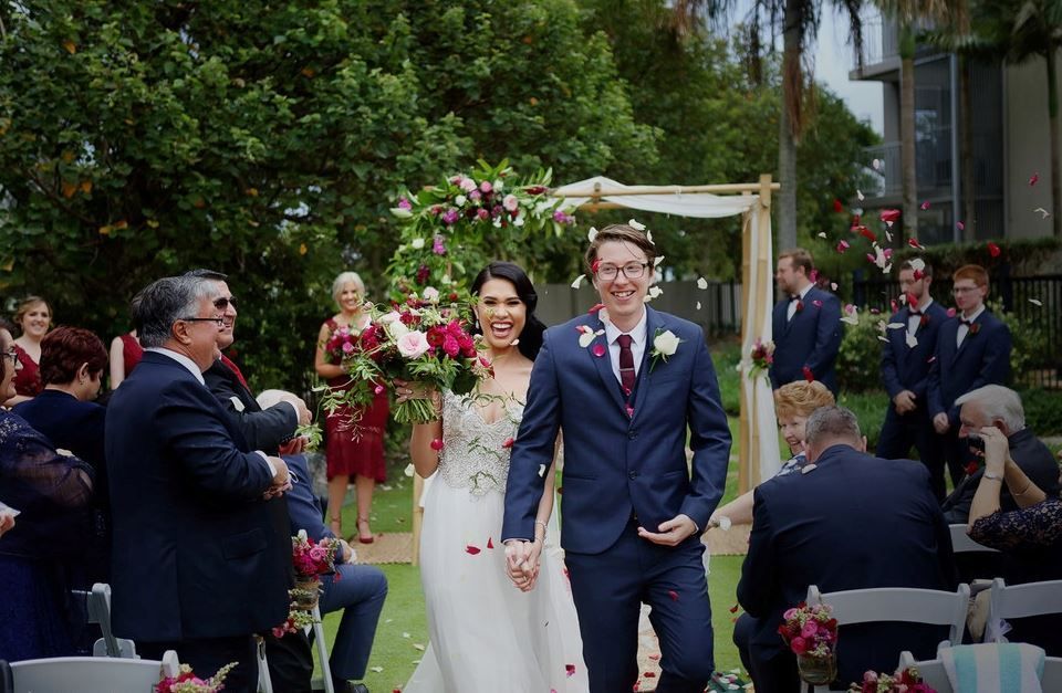 A bride and groom are walking down the aisle at their wedding.