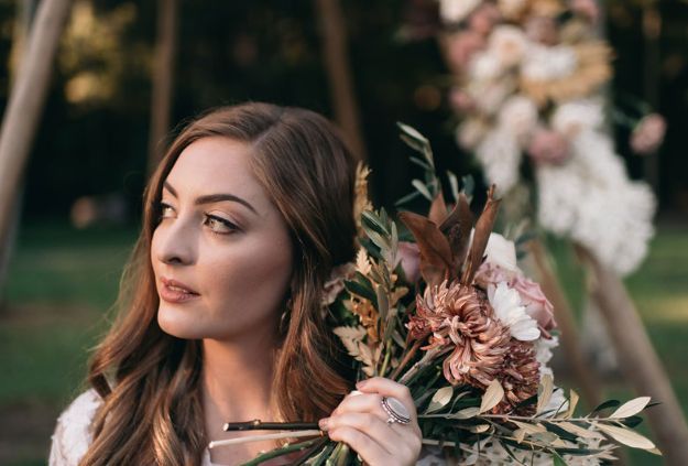 A woman is holding a bouquet of flowers in her hand.