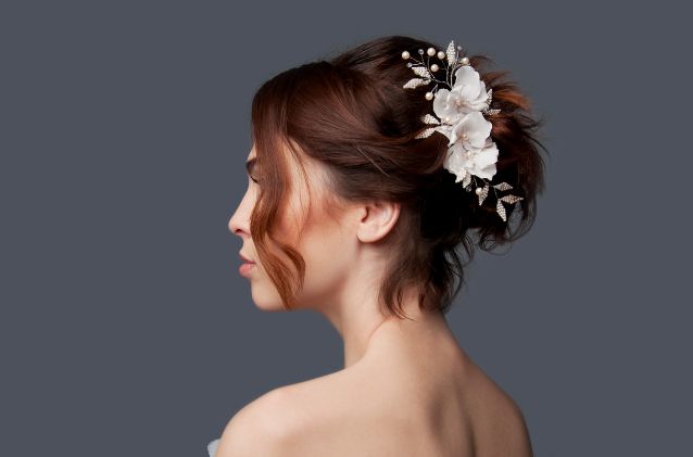 A woman in a wedding dress with a flower in her hair.