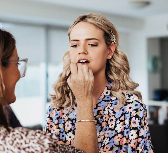 A woman is applying makeup to another woman 's face