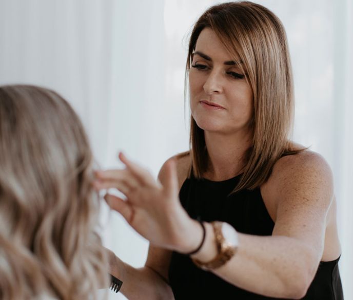 A woman in a black tank top is talking to another woman.