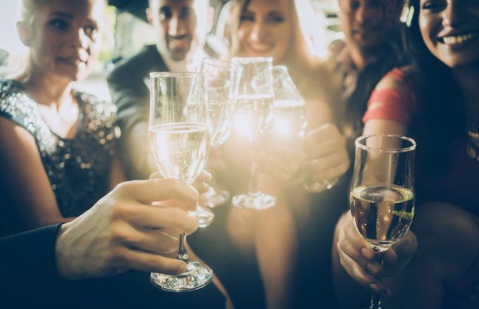 A group of people are toasting with champagne glasses at a party.