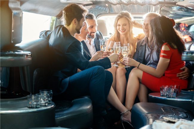 A group of people are sitting in a limousine toasting with champagne.