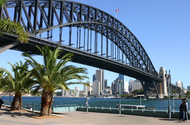 A bridge over a body of water with palm trees in the foreground