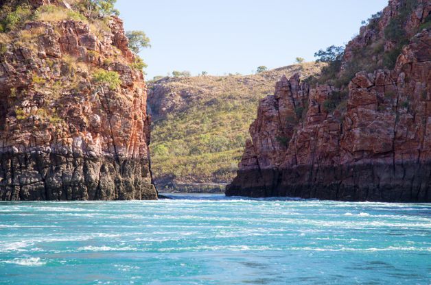 A large body of water surrounded by rocky cliffs and trees.