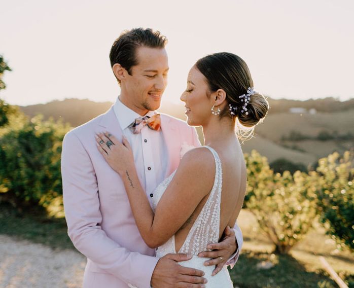 A bride and groom are posing for a picture on their wedding day.