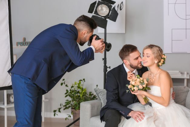 A photographer is taking a picture of a bride and groom.