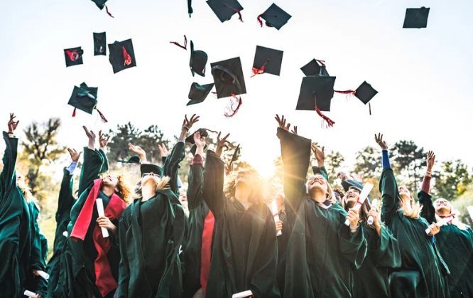 A group of graduates are throwing their caps in the air.