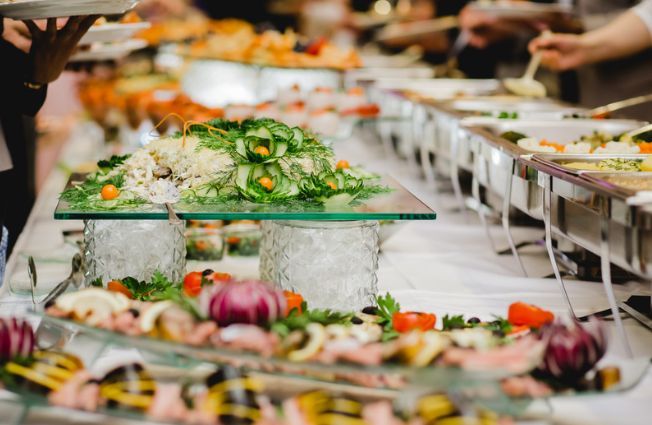 A buffet table with a variety of food on it.