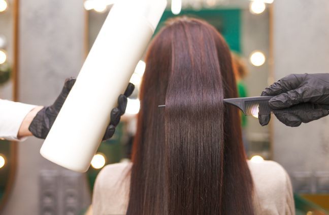 A woman is getting her hair dyed in a salon.