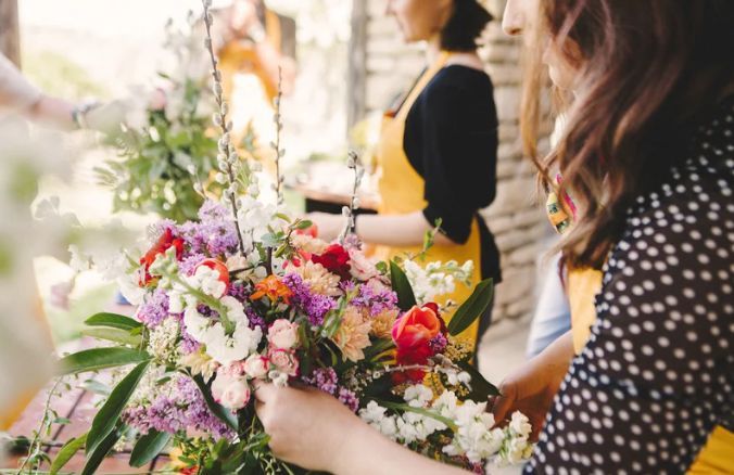 A woman is holding a bouquet of flowers in her hands.