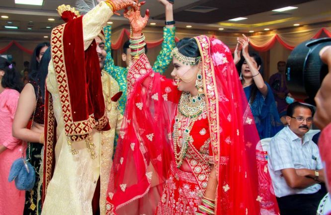 A bride and groom are dancing in front of a crowd at a wedding reception.