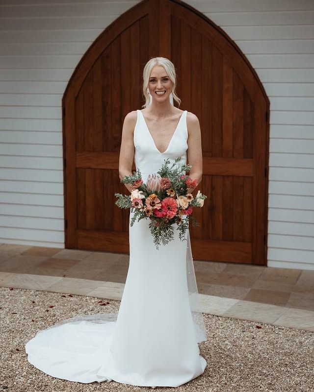 The bride is wearing a white dress and holding a bouquet of flowers.