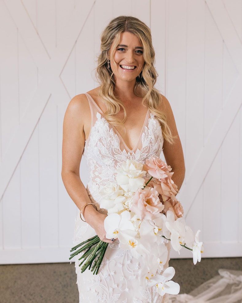 The bride is wearing a white dress and holding a bouquet of flowers.