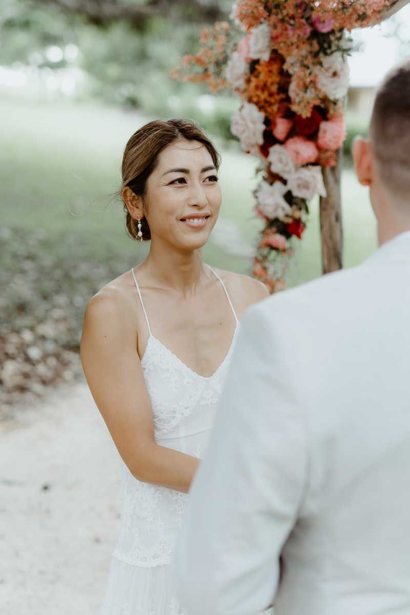 A bride and groom are looking at each other during their wedding ceremony.