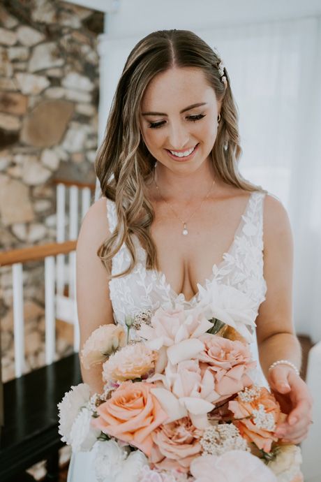 A bride in a white dress is holding a bouquet of flowers.