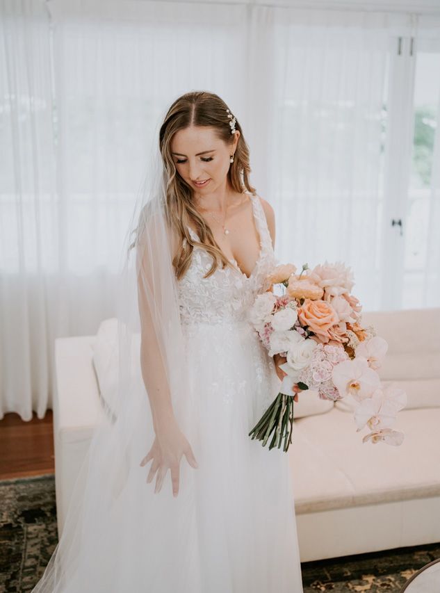 A bride in a wedding dress is holding a bouquet of flowers.