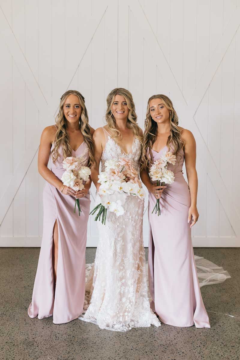 A bride and her bridesmaids are posing for a picture.