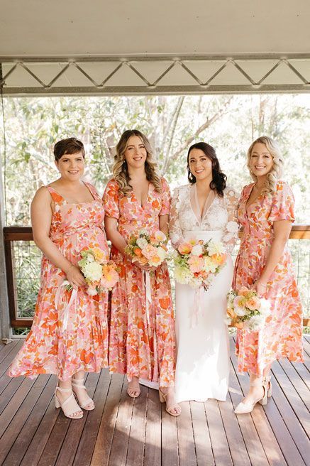 A bride and her bridesmaids are posing for a picture on a porch.