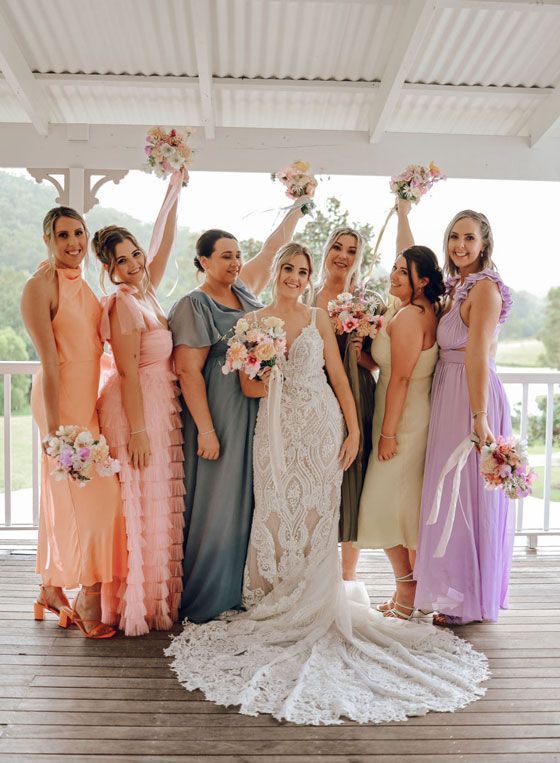A bride and her bridesmaids are posing for a picture.