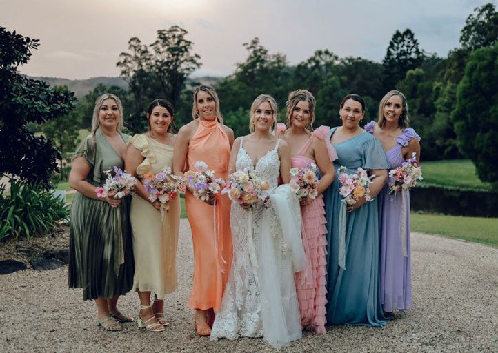 A bride and her bridesmaids are posing for a picture.