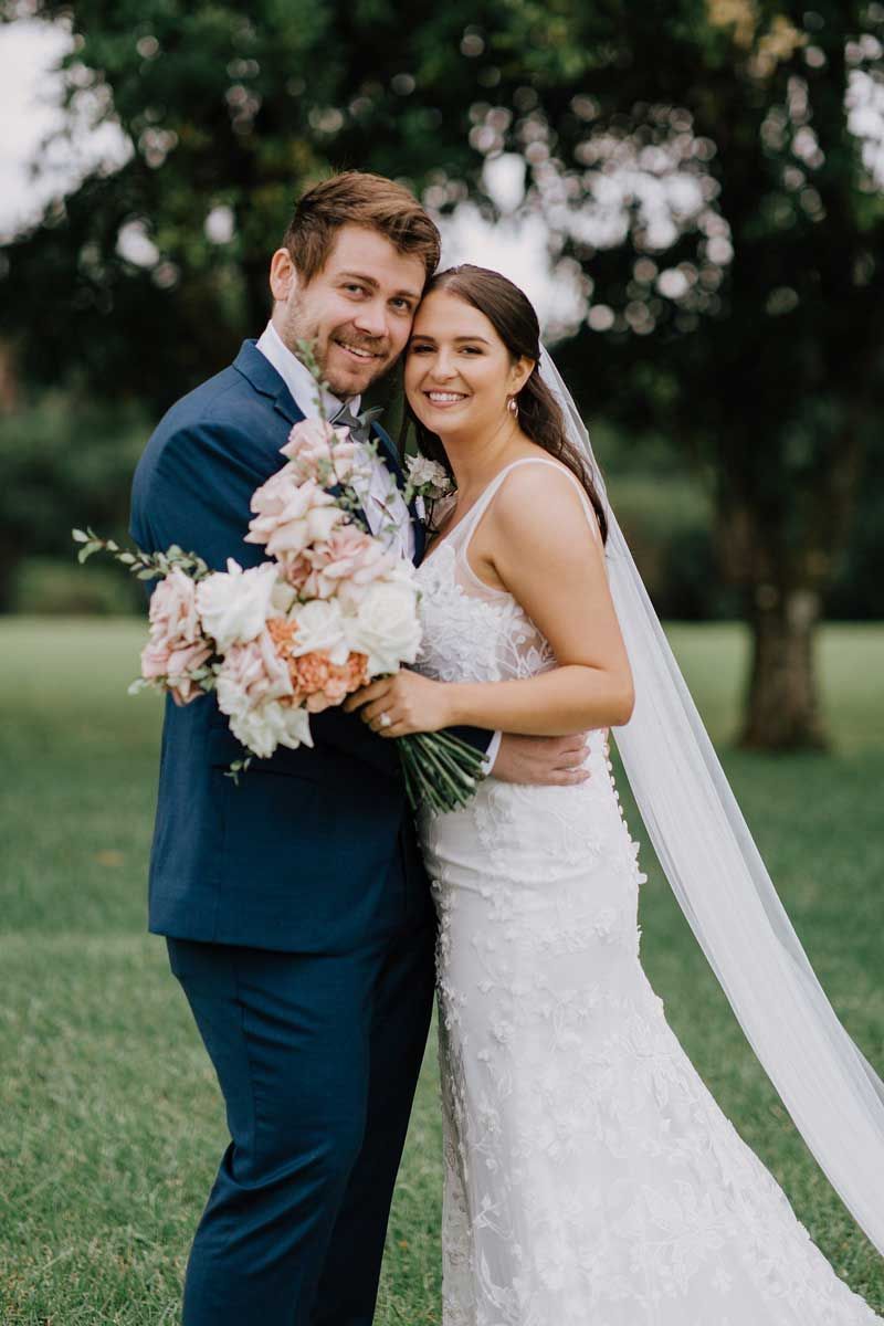 A bride and groom are posing for a picture on their wedding day.