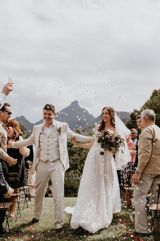 A bride and groom are walking down the aisle at their wedding.
