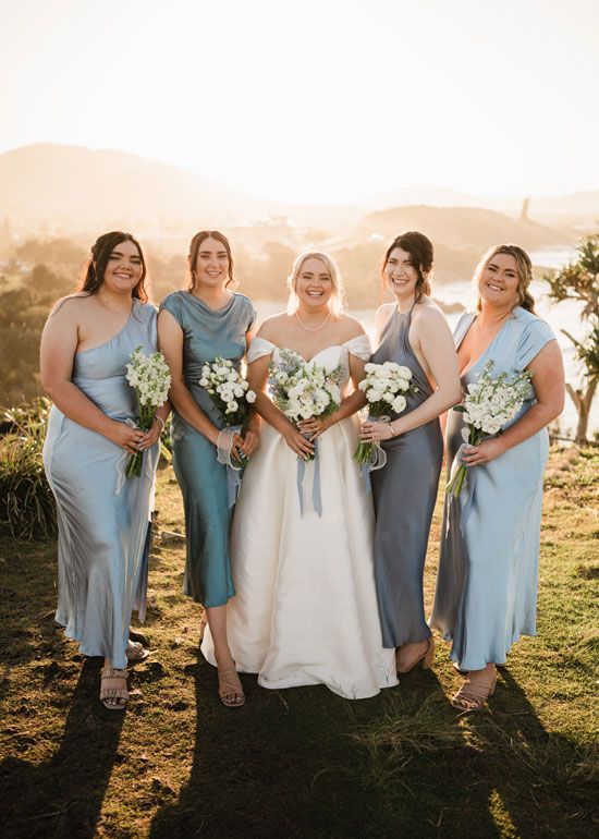 A bride and her bridesmaids are posing for a picture.