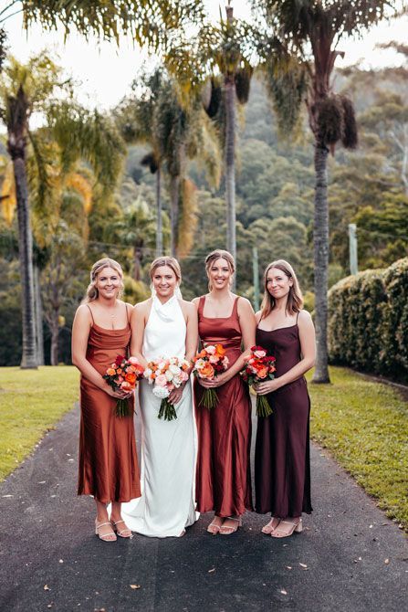 A bride and her bridesmaids are posing for a picture.