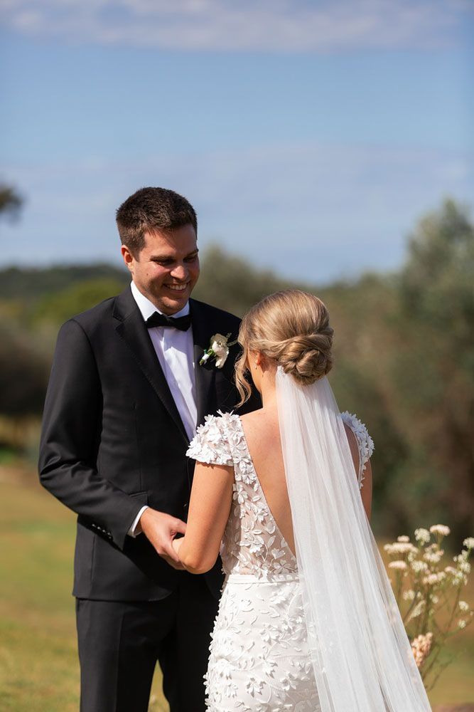 A bride and groom are looking at each other during their wedding ceremony.