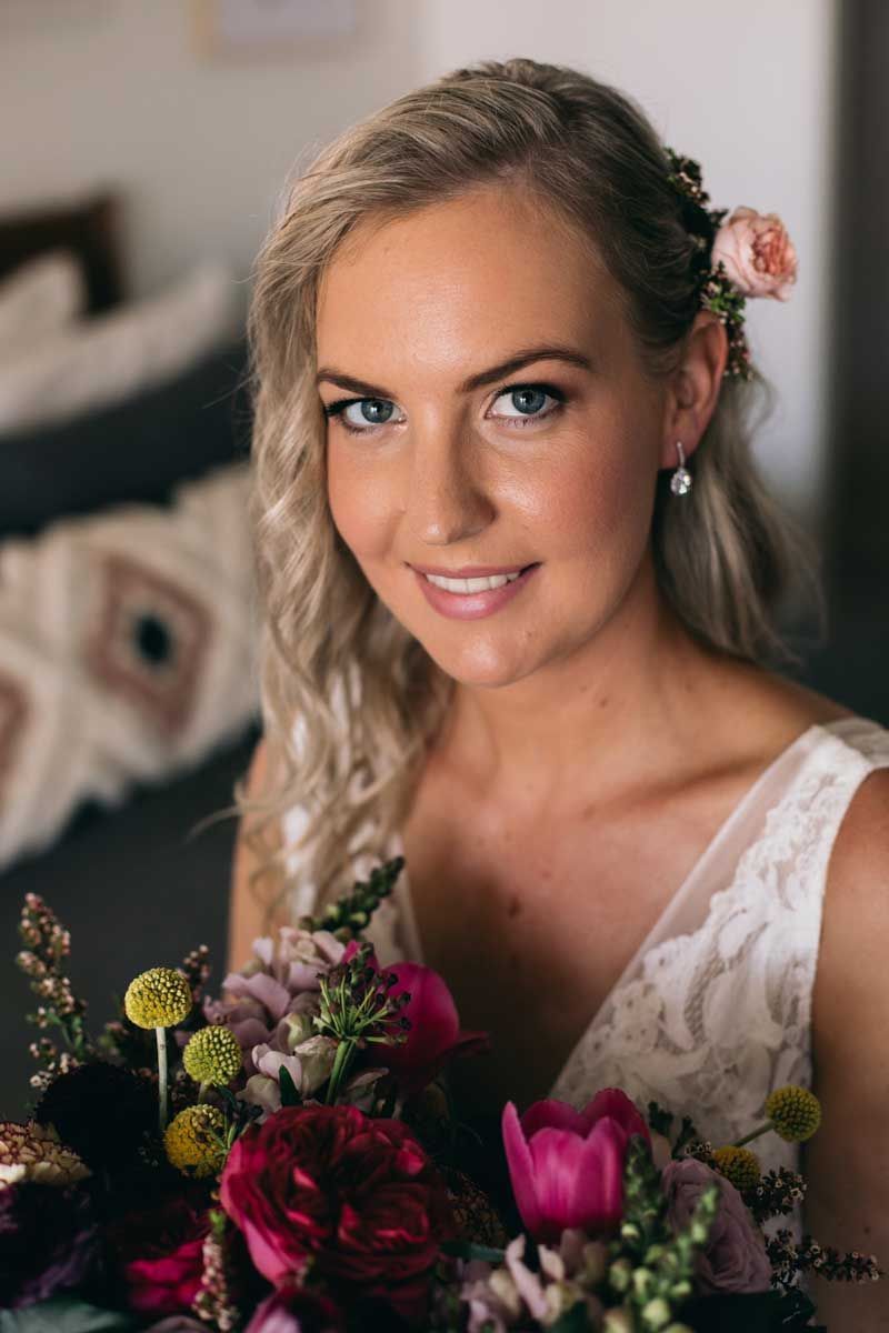 A woman in a wedding dress is holding a bouquet of flowers.