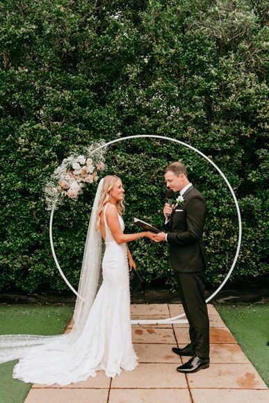 A bride and groom are holding hands during their wedding ceremony.